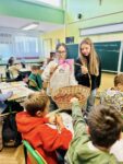 Uczennice wręczające swoim kolegom słodkości