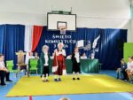 Uczniowie w kostiumach na tle scenografii