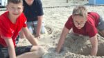 Trzej chłopcy bawiący się na plaży
