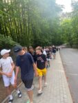 Uczniowie idący chodnikiem z nad morza